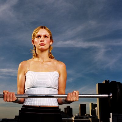 Portrait of a young woman carrying a barbell