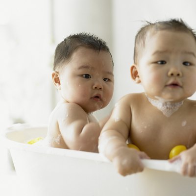 Twin baby boys playing in the bathtub