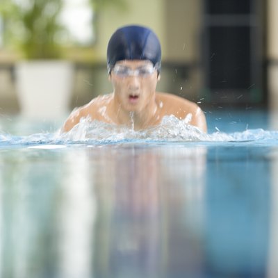 Man swimming in the pool, front view, defocused