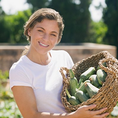 Woman holding a basket of courgettes