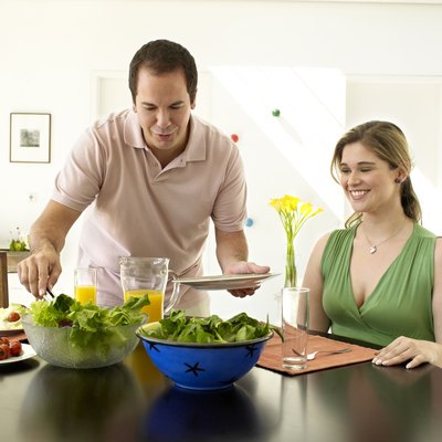 Couple smiling and eating a salad