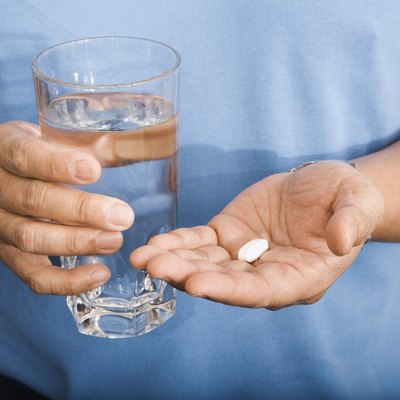 Man Holding Pill and Glass of Water
