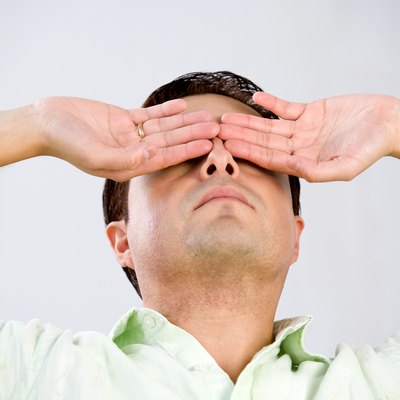 Studio shot of man with hands over eyes