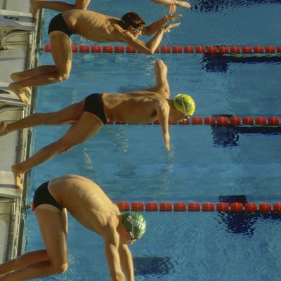 Swimmers diving into pool