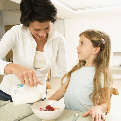 Close-up of a young woman serving breakfast to her daughter
