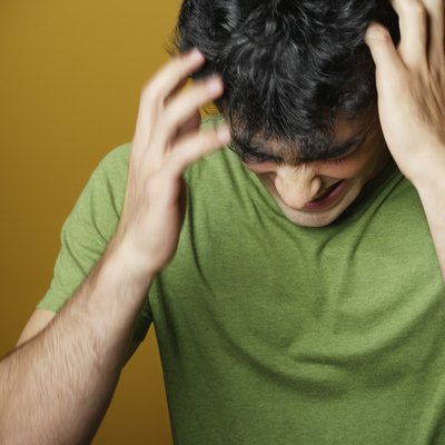 Young man holding head