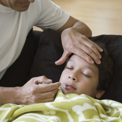 Father taking temperature of sick son