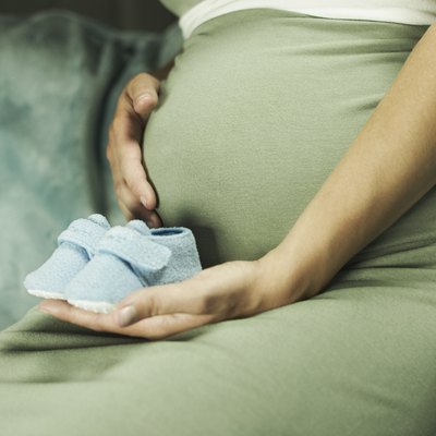 Cropped pregnant woman with blue booties