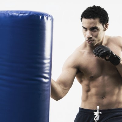 Mixed Race man using punching bag