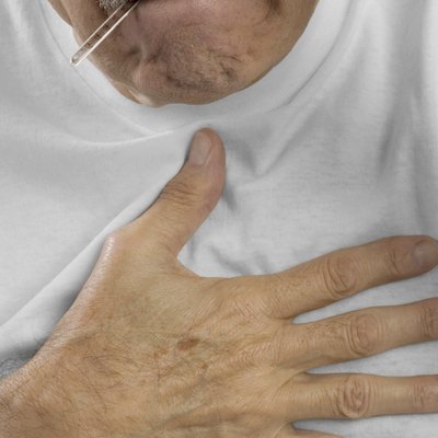Senior man with hand on chest and thermometer in mouth
