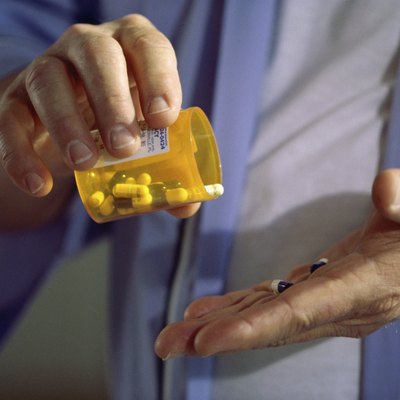 Close-up of a person holding a bottle of pills