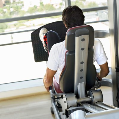 Rear view of a man using a leg press machine
