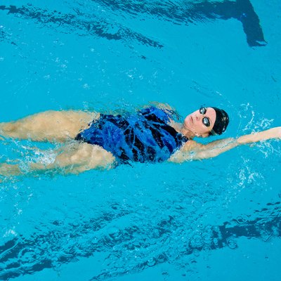 Woman swimming backstroke in pool