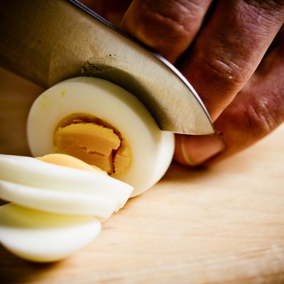 Close-up of cook slicing hard-boiled egg