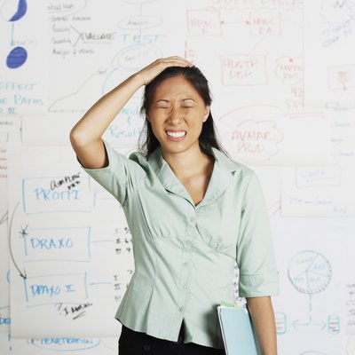 Frustrated Asian businesswoman in front of whiteboard