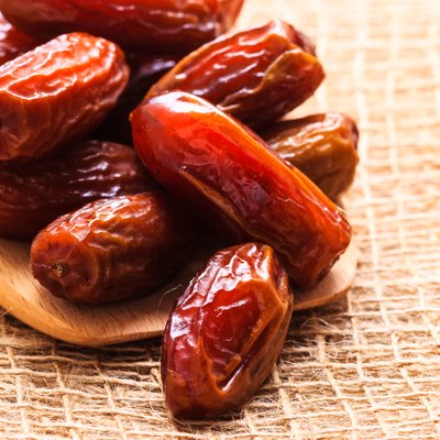 dried dates on wooden spoon cloth background