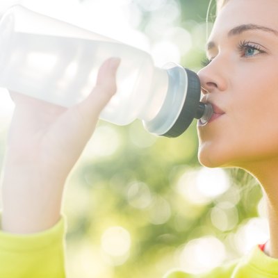 Fit blonde drinking from sports bottle