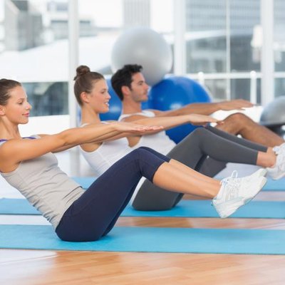 Side view of class stretching on mats at yoga class in fitness studio