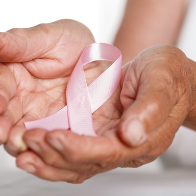 Elder woman hands holding pink breast cancer awareness ribbon