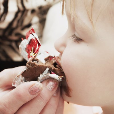 little girl eating chocolate candy. Pleasure.