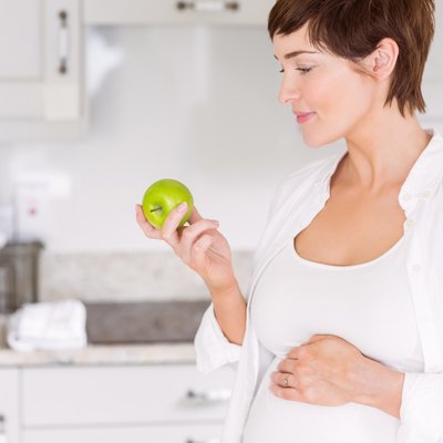 Pregnant woman eating an apple