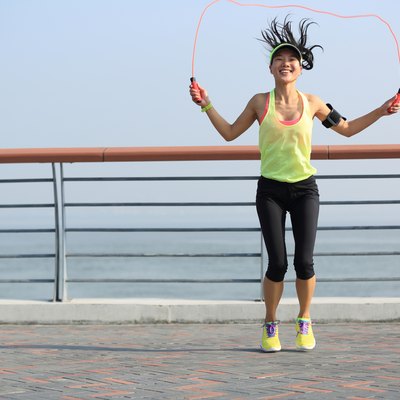 young fitness woman jumping rope at seaside