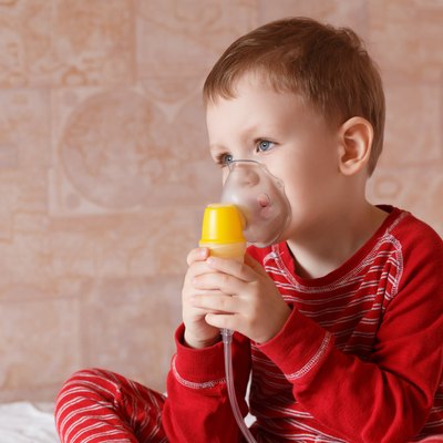 Sick little boy makes inhalation mask for breathing at home