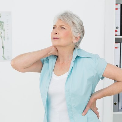 Senior woman suffering from neck pain in medical office