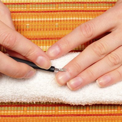 Woman trimming cuticles of hand, manicure