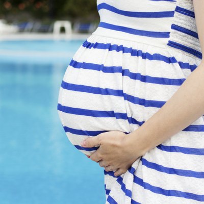 Beautiful pregnant woman relaxing in the park