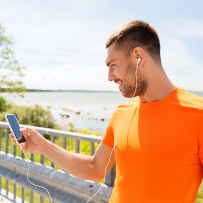 smiling young man with smartphone and earphones