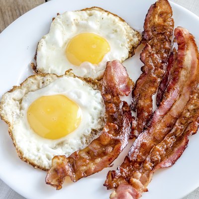 Fried eggs with bacon on the wooden table