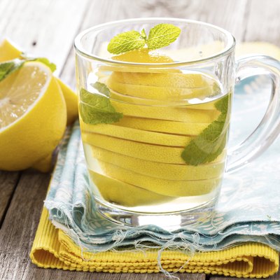 Tea with mint and whole lemon in a transparent cup
