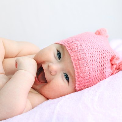 laughing baby girl in pink hat