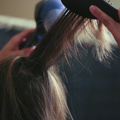 Woman Blow Drying Hair - Stock Image
