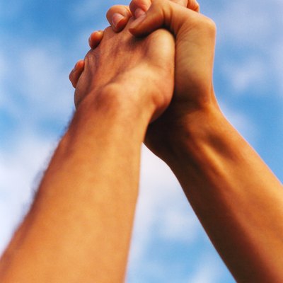 low angle view of hands grasped with arms raised