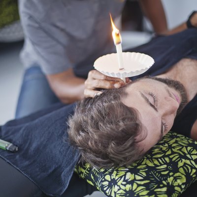 man having an ear candle therapy
