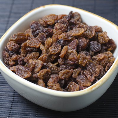 Bowl of raisins on dark background