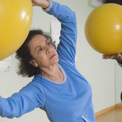 Senior Woman Using Exercise Ball in Fitness Class