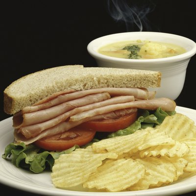 Ham sandwich with potato chips and soup