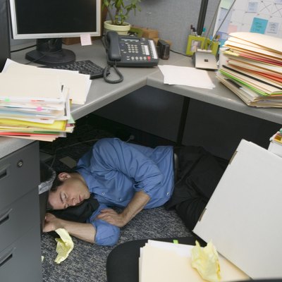 Businessman sleeping in cubicle