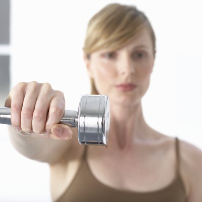 Woman holding dumb-bell, portrait, (focus on dumb-bell)