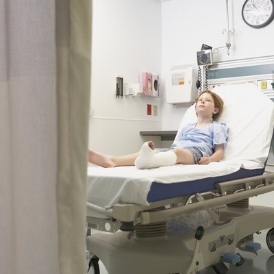 Young boy with broken leg laying in hospital bed