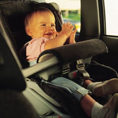 Baby sitting in a car seat and clapping hands