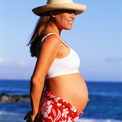 Pregnant woman standing near coast
