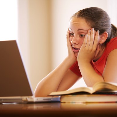 Teenage girl with laptop doing homework