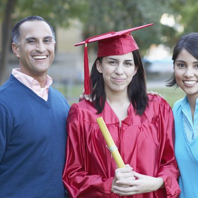 Portrait of a female graduate standing with a mid adult man and a young woman