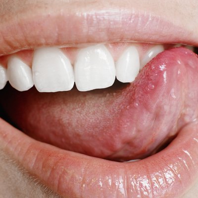 Young woman licking lips, close-up of mouth