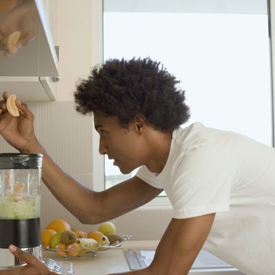 Man putting fruit in blender