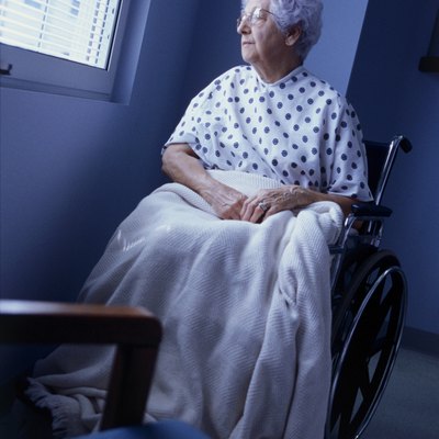 Female patient sitting in a wheelchair looking out of a window